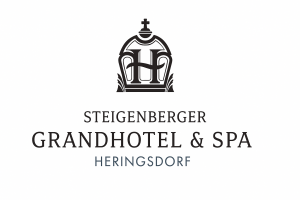 Logo des Steigenberger Grandhotel & Spa Heringsdorf mit einem stilisierten kronenähnlichen Emblem über dem Hotelnamen in fetten schwarzen und blauen Buchstaben auf weißem Hintergrund.